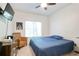 Bedroom with a ceiling fan, large window, blue bedspread, dresser, and a wicker chair at 1441 Hada Ln, Lawrenceville, GA 30043