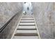 Basement staircase with gray tiled walls and white textured steps leading to the upper level at 1441 Hada Ln, Lawrenceville, GA 30043