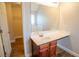 Bathroom vanity featuring wood cabinets, a white countertop, large mirror, and wood-look floors at 4135 Arch Pass, Cumming, GA 30040