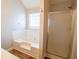 Bright bathroom showcasing a soaking tub, glass-enclosed shower, and wood-look flooring at 4135 Arch Pass, Cumming, GA 30040