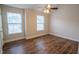 A bedroom featuring wood-look flooring, neutral walls, ceiling fan, and bright windows at 4135 Arch Pass, Cumming, GA 30040