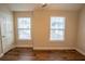 Well-lit bedroom with wood-look flooring, white trim, and windows with neighborhood view at 4135 Arch Pass, Cumming, GA 30040