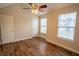 A bedroom featuring wood-look flooring, neutral walls, ceiling fan, and bright windows at 4135 Arch Pass, Cumming, GA 30040