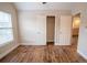 A bedroom featuring wood-look flooring, neutral walls, a window and a closet with double doors at 4135 Arch Pass, Cumming, GA 30040