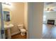 Stylish powder room featuring a pedestal sink, toilet, and wood flooring, leading into a bright living space at 4135 Arch Pass, Cumming, GA 30040