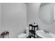 Neat powder room with white fixtures, a round mirror, and modern decorative items at 510 Abeer St, Temple, GA 30179
