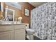 Cozy bathroom with white cabinets and a shower featuring a floral patterned shower curtain at 5996 Eagle Tiff Ln, Sugar Hill, GA 30518