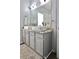 Bathroom featuring double sinks, granite countertop, and modern fixtures at 5996 Eagle Tiff Ln, Sugar Hill, GA 30518