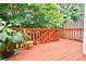 Outdoor deck, wood stained, with views of the trees and landscape at 5996 Eagle Tiff Ln, Sugar Hill, GA 30518