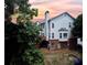 Rear exterior showcasing a white townhouse with a brick base, a small deck and green landscaping at 5996 Eagle Tiff Ln, Sugar Hill, GA 30518