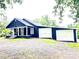 Charming blue home with white trim features a covered porch, detached garage, and well-maintained landscaping at 776 Green Dr, Canton, GA 30114