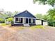 Charming home features a covered porch with a swing and a detached garage with crossbuck doors at 776 Green Dr, Canton, GA 30114