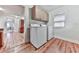 Well-lit laundry room with wood floors, washer, dryer, and ample cabinet storage at 776 Green Dr, Canton, GA 30114