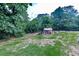 Backyard shed with tools and debris around it, amid a lush green landscape at 776 Green Dr, Canton, GA 30114
