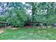 Open wooden shed with overgrown plants, trees, and grass in a spacious backyard at 776 Green Dr, Canton, GA 30114