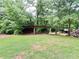Covered storage area amidst lush greenery, perfect for storing wood and other outdoor items at 776 Green Dr, Canton, GA 30114