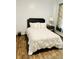 Bright bedroom with a queen-sized bed, stylish headboard, and sleek wood floors at 870 Mayson Turner Rd # 1207, Atlanta, GA 30314