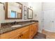 This bathroom features double sinks with granite countertops, wooden cabinetry, and framed mirrors at 300 Brackin Trce, Grayson, GA 30017