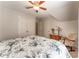 Bedroom with floral bedspread, complimented by white walls, ceiling fan, closet, and wooden rocking chair at 300 Brackin Trce, Grayson, GA 30017