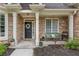 Inviting front porch with stone pillars, decorative wreath, and charming seating area at 300 Brackin Trce, Grayson, GA 30017