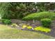 This landscaped garden features flowering plants, bushes, decorative mulch, and an ornament at 300 Brackin Trce, Grayson, GA 30017