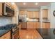 Open kitchen features light wood cabinets, stainless appliances, and granite countertops at 300 Brackin Trce, Grayson, GA 30017