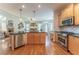 Open kitchen and living space with stainless appliances, granite counters, wood cabinets and wood floors at 300 Brackin Trce, Grayson, GA 30017