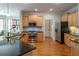 Open-concept kitchen features wood floors, stainless appliances, granite counters and light wood cabinetry at 300 Brackin Trce, Grayson, GA 30017