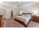 This spacious main bedroom features a ceiling fan, tray ceiling, and two bedside tables with lamps at 300 Brackin Trce, Grayson, GA 30017