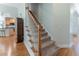 Carpeted staircase with white railings and a view of the kitchen at 300 Brackin Trce, Grayson, GA 30017