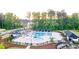 Aerial view of a community pool featuring shaded structures and fenced perimeters, surrounded by trees and homes at 3303 Hawthorn Farm Blvd, Loganville, GA 30052