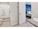 Bright bathroom features a shower with decorative curtain and opens to the primary bedroom at 3303 Hawthorn Farm Blvd, Loganville, GA 30052