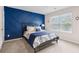 Stylish bedroom with blue accent wall, a queen bed, and natural light at 3303 Hawthorn Farm Blvd, Loganville, GA 30052