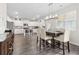 Bright dining area open to the kitchen, featuring a wooden table and chairs and modern lighting fixture at 3303 Hawthorn Farm Blvd, Loganville, GA 30052