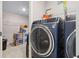 A modern laundry room with a front-load washer and dryer and wire shelving at 3303 Hawthorn Farm Blvd, Loganville, GA 30052