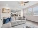 Bright living room with large windows, open floor plan, light gray sofa, and view into the kitchen at 3303 Hawthorn Farm Blvd, Loganville, GA 30052