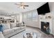Inviting living room with a fireplace, TV, gray sofa, and open flow to the kitchen and dining area at 3303 Hawthorn Farm Blvd, Loganville, GA 30052
