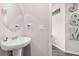 A powder room featuring a sleek pedestal sink and modern fixtures at 3303 Hawthorn Farm Blvd, Loganville, GA 30052