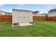 Backyard storage shed with ramp, featuring decorative landscaping and wooden fencing at 3303 Hawthorn Farm Blvd, Loganville, GA 30052