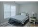 Small bedroom with a metal bed frame, a side table, and a window with blinds for privacy at 6985 Shane Ln, Cumming, GA 30028