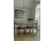 Modern dining room with table, chairs, chandelier, and arched window at 6985 Shane Ln, Cumming, GA 30028