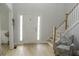 Bright and airy foyer with hardwood floors, chair, and staircase at 6985 Shane Ln, Cumming, GA 30028