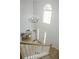 Bright foyer with a chandelier, arched window, white door, and dining area view at 6985 Shane Ln, Cumming, GA 30028