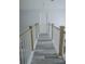 Upstairs hallway featuring gray wood floors, white railings, and a bright white door at 6985 Shane Ln, Cumming, GA 30028