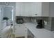 Bright kitchen boasts white cabinets, stainless steel appliances, and a view into the dining area at 6985 Shane Ln, Cumming, GA 30028