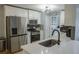 Modern kitchen with stainless steel appliances, white cabinets, and a stylish faucet and sink at 6985 Shane Ln, Cumming, GA 30028