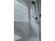 Contemporary shower stall with marble-look tile, a rainfall showerhead, and frosted window for privacy at 6985 Shane Ln, Cumming, GA 30028