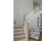 Staircase with white railings and wood treads, complemented by decorative seahorse and chair at 6985 Shane Ln, Cumming, GA 30028