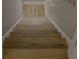 Wooden staircase with light wood treads and white risers leading to a bright hallway at 6985 Shane Ln, Cumming, GA 30028