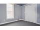 Bedroom with neutral carpet, blue walls, and white closet doors at 996 Palmetto Sw Ave, Atlanta, GA 30314